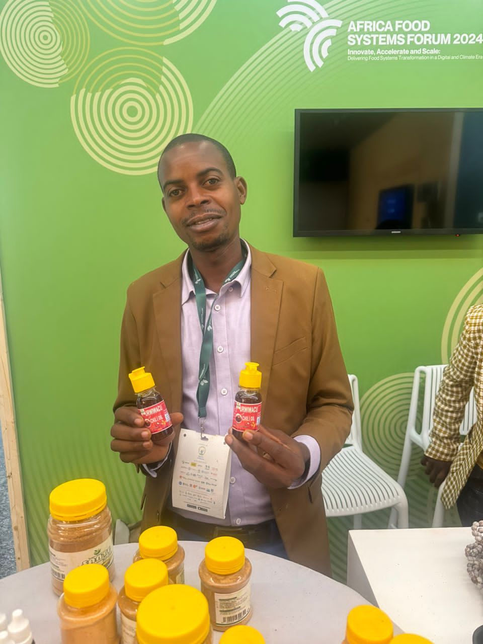 A RYCP entrepreneur showcasing a processed chili oil product at Africa Food Systems Forum 2024